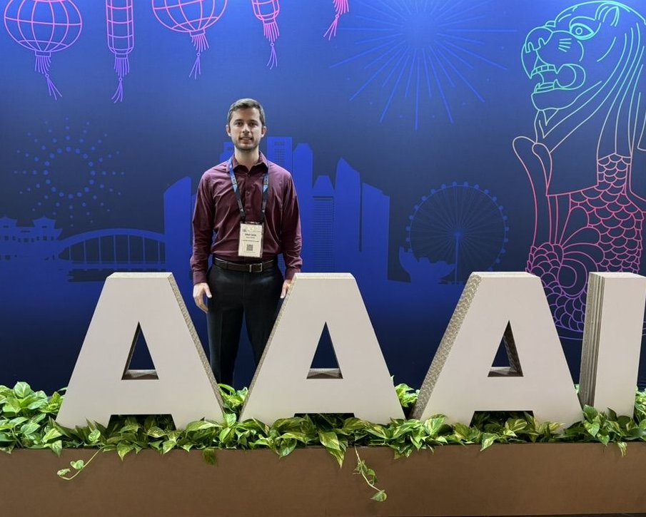 Standing with the AAAI letters at the 2026 conference in Singapore